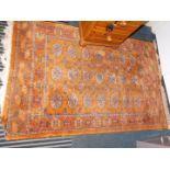 A Tekke style wool rug with orange ground and geometric borders, 170cm x 102cm.