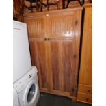 A Heathland Furniture limed oak double wardrobe, with carved panel doors, 188cm high, 126cm wide,