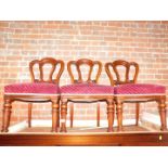 Three Victorian mahogany dining chairs, with burgundy velvet seats.