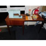 A Singer sewing machine in a teak cabinet, with accessories.