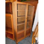 An early 20thC oak glazed bookcase, enclosing four fixed shelves, 172cm high, 90cm wide, 29cm deep.