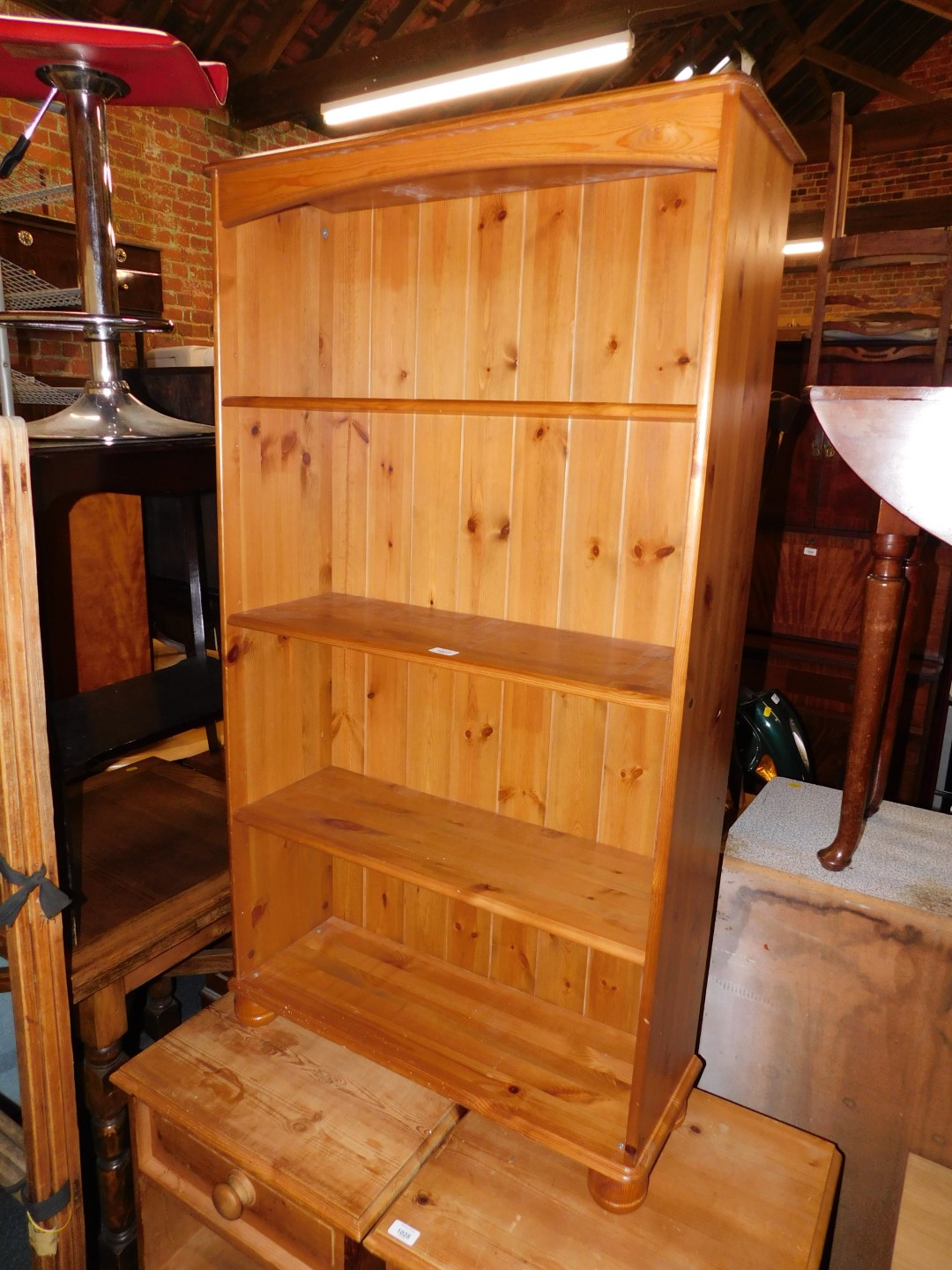 A pine bookcase enclosing three adjustable shelves, 134cm high, 75cm wide, 27cm deep.