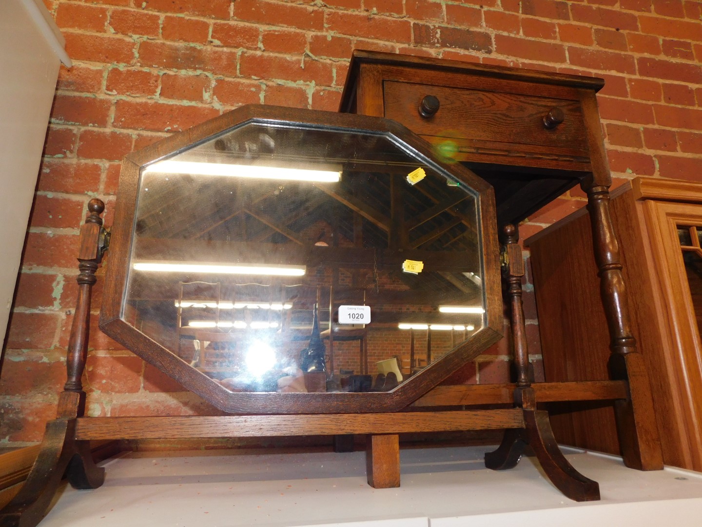 An early 20thC swing frame mirror, 56cm wide, together with a stained oak side table with single