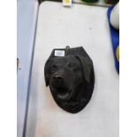 A carved wooden wall plaque modelled as a dog's head.