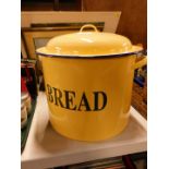 A custard yellow and blue trimmed enamel bread bin, 35cm diameter.