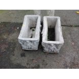 A pair of reconstituted stone rectangular planters, cast with cherubs.
