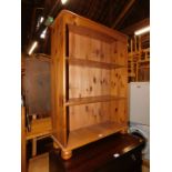 A pine bookcase enclosing two adjustable shelves, 102cm high, 75cm wide, 27cm deep.