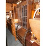 An early 20thC oak bureau bookcase, with lead glazed doors above three drawers, 198cm high, 76cm