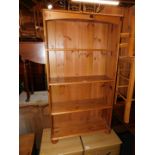 A pine bookcase enclosing three adjustable shelves, 134cm high, 75cm wide, 27cm deep.