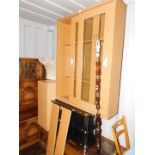 An oak effect bookcase, with two sliding glazed doors, enclosing six adjustable shelves, 131cm high,