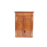 A George III oak and mahogany wall hanging corner cupboard, with two doors opening to reveal three