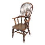 A Victorian oak and elm Windsor chair, with a carved and shaped splat, solid saddle seat, raised