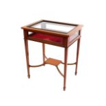An Edwardian satin wood and rosewood cross banded bijouterie table, the hinged lid opening to reveal