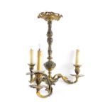 An early 20thC brass three branch chandelier, of foliate scroll rococo form, 52cm high.