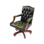 A green leather and mahogany swivel office chair, with button green leather back and overstuffed