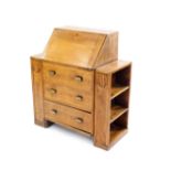 A 1930's light oak bureau bookcase, the fall flap opening to reveal a single drawer and recesses,