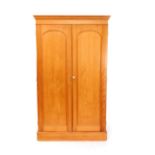 A Victorian pine double compactum wardrobe, the outswept pediment over two doors opening to reveal a