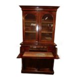 A Victorian mahogany secretaire bookcase, the outswept pediment over a pair of glazed doors, opening