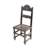 A 17thC oak country single chair, with foliate scroll carved crest rail and bar back, solid seat,