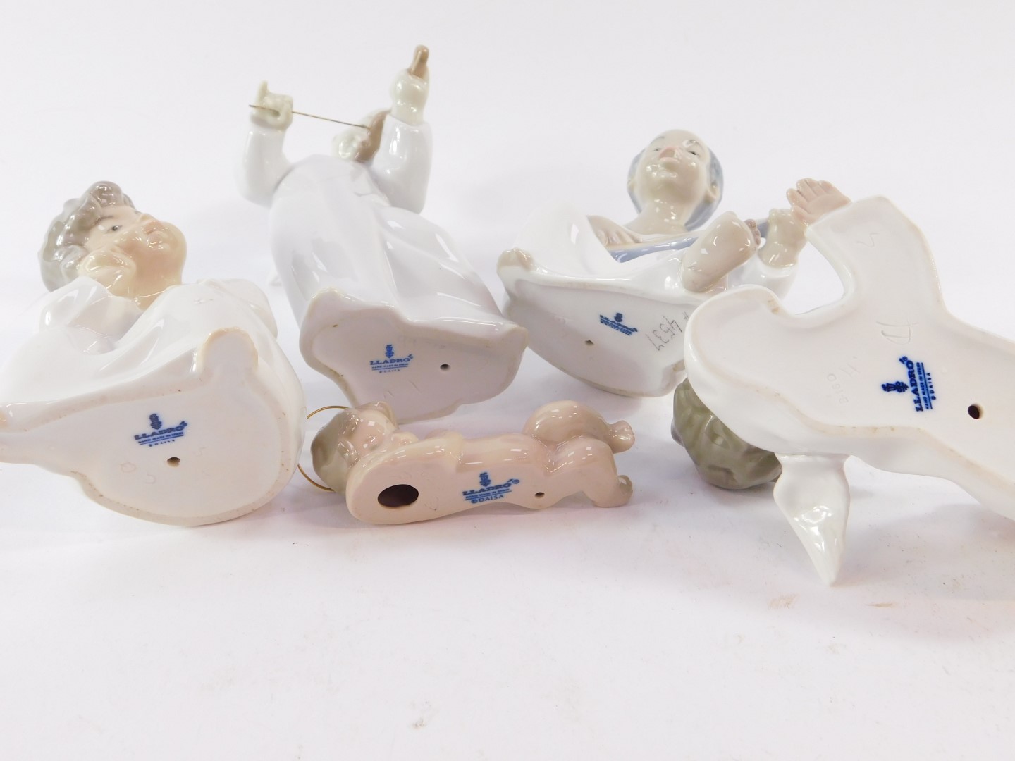 Four Lladro porcelain figures modelled as cherubs, two modelled in contemplation, one playing a - Bild 2 aus 2