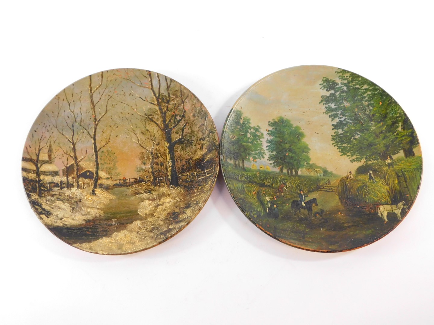 A pair of Watcombe late 19thC terracotta plates, painted with a harvesting scene and winter