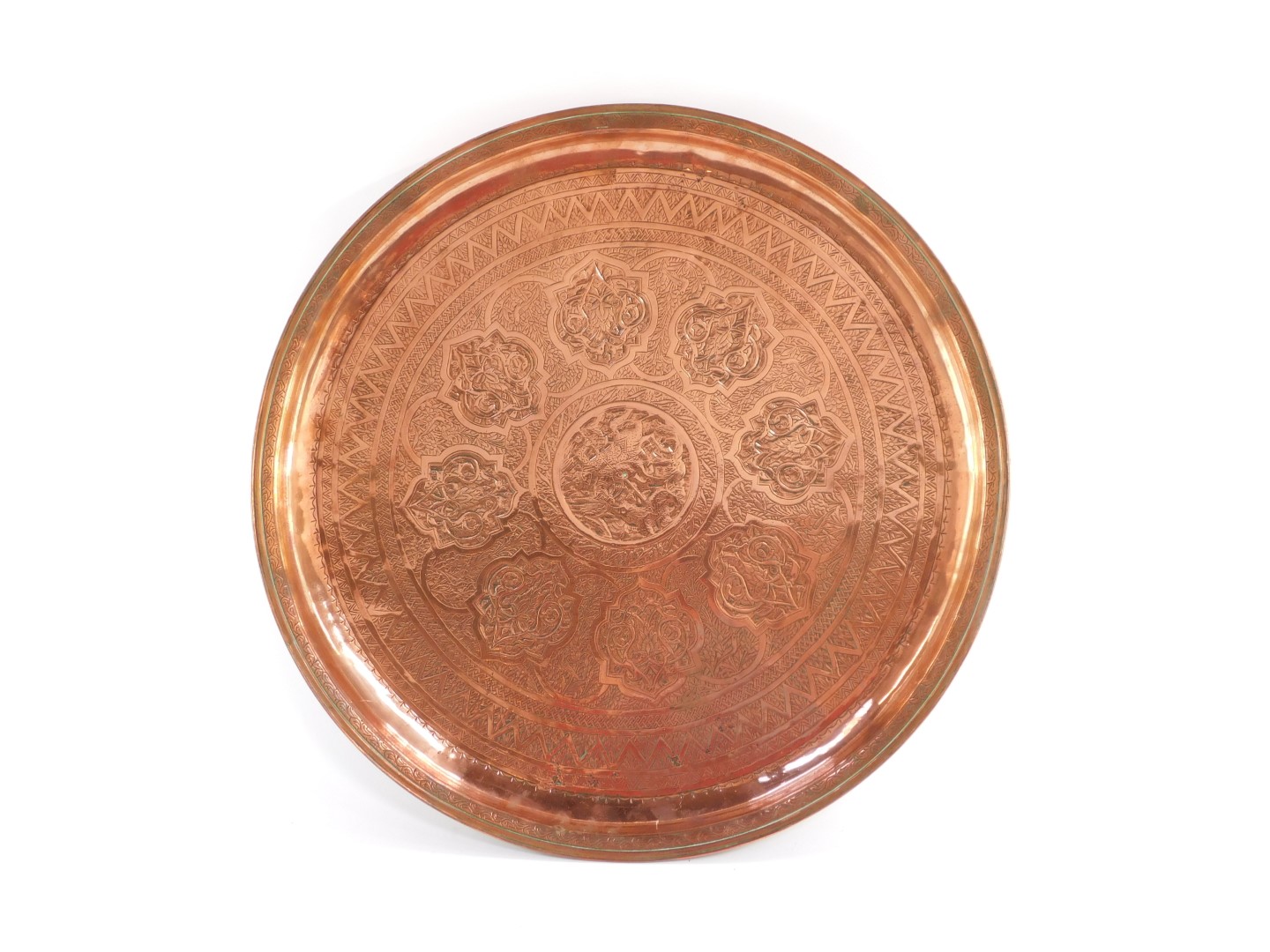 An Indian copper tray, engraved centrally with an Indian Prince on horse back spearing a lion,