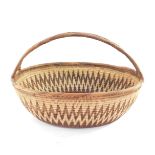 A Papua New Guinea Highlands basket, of oval form with splayed end over handle, decorated with