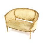 A late Victorian gilt wood two seater sofa in the French taste, upholstered in gold floral damask,