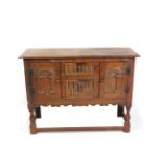 An Elizabethan style oak sideboard, with a pair of carved graduated central drawers flanked by