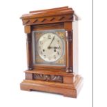 A late Victorian oak cased mantle clock, silver dial, with brass scroll spandrels, bearing Arabic