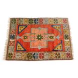 A Kelim rug, red ground decorated with floral motifs within a repeating floral border, 183cm x