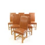 A set of six light oak and tan leather single dining chairs, with over stuffed seats and backs,