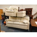 A cream leather three seater sofa, 225cm wide, together with a recliner armchair, and a cream