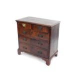 A George III mahogany chest, of two short over three long graduated drawers, raised on bracket feet,