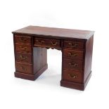 An early 20thC mahogany twin pedestal desk, by James Shoolbred & Company, London., with one long and