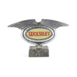 A Wolseley mid 20thC chrome light up grill badge, raised on a marble base, 16cm wide.