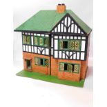 An early 20thC mock Tudor doll's house, the front opening as two doors to reveal four rooms, 66cm
