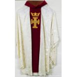 An ecclesiastical vestment robe, with crown and cross motif on a red ground, with white body,
