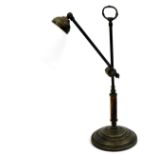 An early 20thC brass desk light, with loop handle, on plain wooden stem and stepped circular base,