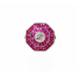 An octagonal ruby and diamond ring, with central round brilliant cut diamond, in rub over setting,