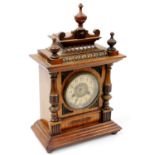 A late 19thC walnut cased mantel clock, the 11cm diameter Arabic dial in a shaped case, surmounted