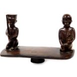 A 20thC African tribal carving, formed as two removable figures on a shaped block base, 46cm wide.