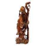 A Chinese root carving of a beaded sage, holding a staff on a shaped base, probably early 20thC,