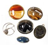 A group of stone set brooches, comprising a bulls eye agate and silver framed cabochon brooch, a