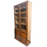 A Victorian mahogany library bookcase, the two glazed doors, raised above two arched cupboards on