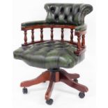 A green leather finish captain's office chair, with overstuffed back, arms and serpentine seat, on