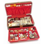 A brown travel case and contents of jewellery, comprising mainly clip on earrings, a silver
