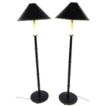 A pair of Chinese design bamboo standard lamps, each with shaped shades, turned stems and circular