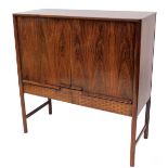 A vintage teak cabinet, with double cupboards, raised above two drawers on turned legs, joined by