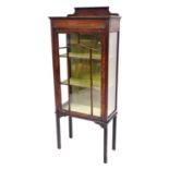 An Edwardian mahogany display cabinet, with glazed sides and single door, opening to reveal two